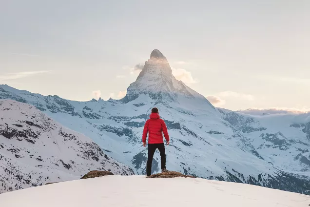 A man standing on a snow-capped mountain. Photo.