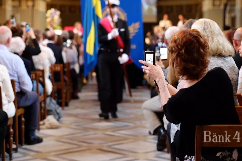 People in the audience are taking pictures on the graduation ceremony. Photo: Helena Bergqvist.